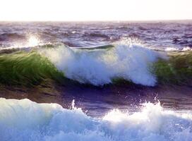 Wave breaking with sunlight coming through from behind photo