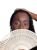 Black woman holding wooden fan before face photo