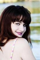 Young Teen Girl Looking Over Shoulder Smiling At River photo