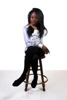 joven africano americano mujer medias camisa taburete foto