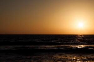 Sunset Golden Sky Over Dark Ocean Waves photo