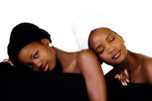 Two Black Sisters Standing Behind Black Cloth photo