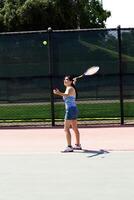 Hispano adolescente niña servicio tenis pelota con raqueta foto