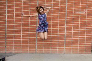 flaco asiático americano mujer saltando en vestir foto