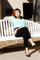 Young Asian American Woman Sitting On Bench photo