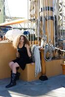 Mixed Race Attractive Young Woman Sitting On Sailing Ship photo