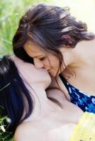 caucásico y asiático americano mujer besos al aire libre foto