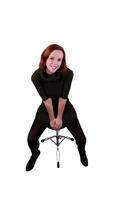 redheaded woman sitting on stool leaning forward photo