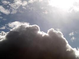 cúmulo lluvia nubes con brillante luz de sol y azul cielo foto