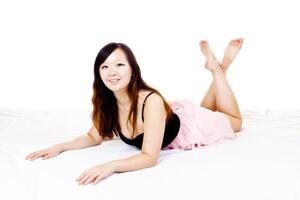 joven chino mujer rosado y negro vestir reclinable foto