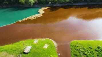 Antenne Drohne Aussicht von verschmutzt Fluss. das Nachwirkungen von übermäßig Phosphat Freisetzung zu das Fluss. Türkis und braun Farben. Umwelt Katastrophe verursacht durch Menschen. ökologisch Anliegen. video