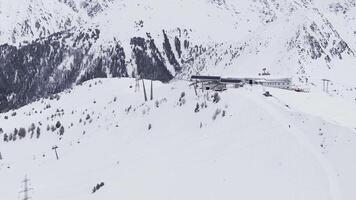 Antenne Schuss von Verbier, Schweiz, zeigt an Schnee bedeckt Steigungen, Ski Aufzüge mit Sessellifte zum Skifahrer, und ein Bahnhof auf das Rechts. video