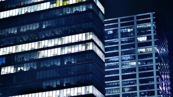 Office buildings by night. Night architectural, buildings with glass facade. Modern buildings in business district. Concept of economics, financial. photo