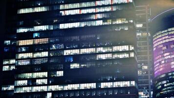 Office buildings by night. Night architectural, buildings with glass facade. Modern buildings in business district. Concept of economics, financial. photo