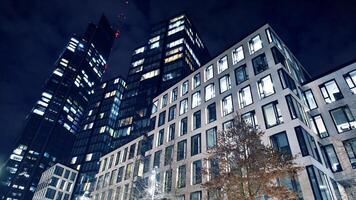 Office buildings by night. Night architectural, buildings with glass facade. Modern buildings in business district. Concept of economics, financial. photo