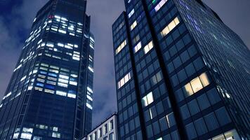 Office buildings by night. Night architectural, buildings with glass facade. Modern buildings in business district. Concept of economics, financial. photo