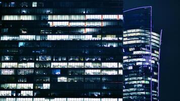 Office buildings by night. Night architectural, buildings with glass facade. Modern buildings in business district. Concept of economics, financial. photo