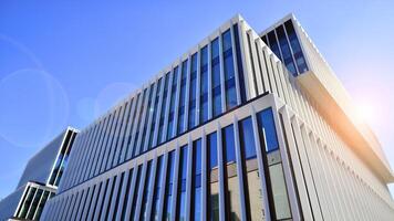 Modern office building in the city with windows and steel and aluminum panels wall. Contemporary commercial architecture, vertical converging geometric lines. photo