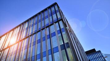 Modern office building with glass facade. Transparent glass wall of office building. Reflection of the blue sky on the facade of the building. photo