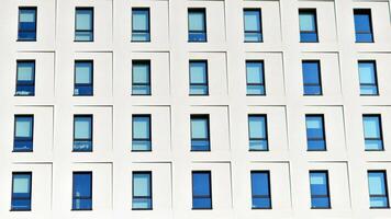 View of a white modern apartment building. Perfect symmetry with blue sky. Geometric architecture detail modern concrete structure building. Abstract concrete architecture. photo