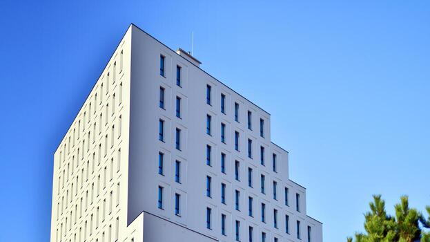 View of a white modern apartment building. Perfect symmetry with blue sky. Geometric architecture detail modern concrete structure building. Abstract concrete architecture. photo