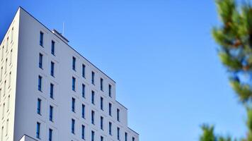 View of a white modern apartment building. Perfect symmetry with blue sky. Geometric architecture detail modern concrete structure building. Abstract concrete architecture. photo