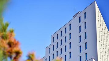 View of a white modern apartment building. Perfect symmetry with blue sky. Geometric architecture detail modern concrete structure building. Abstract concrete architecture. photo