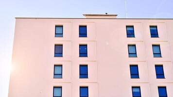 View of a white modern apartment building. Perfect symmetry with blue sky. Geometric architecture detail modern concrete structure building. Abstract concrete architecture. photo