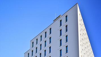 View of a white modern apartment building. Perfect symmetry with blue sky. Geometric architecture detail modern concrete structure building. Abstract concrete architecture. photo