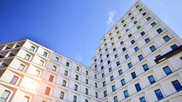 View of a white modern apartment building. Perfect symmetry with blue sky. Geometric architecture detail modern concrete structure building. Abstract concrete architecture. photo