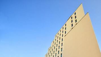 View of a white modern apartment building. Perfect symmetry with blue sky. Geometric architecture detail modern concrete structure building. Abstract concrete architecture. photo