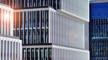 Modern office building in the city with windows and steel and aluminum panels wall. Contemporary commercial architecture, vertical converging geometric lines. photo