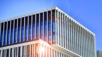 Modern office building in the city with windows and steel and aluminum panels wall. Contemporary commercial architecture, vertical converging geometric lines. photo