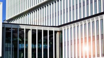 Modern office building in the city with windows and steel and aluminum panels wall. Contemporary commercial architecture, vertical converging geometric lines. photo