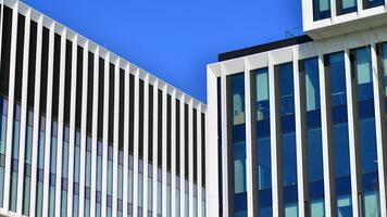 Modern office building in the city with windows and steel and aluminum panels wall. Contemporary commercial architecture, vertical converging geometric lines. photo