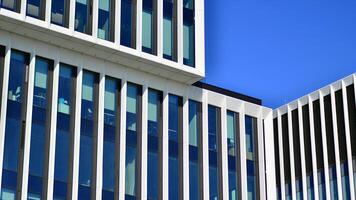 Modern office building in the city with windows and steel and aluminum panels wall. Contemporary commercial architecture, vertical converging geometric lines. photo