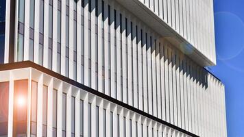 Modern office building in the city with windows and steel and aluminum panels wall. Contemporary commercial architecture, vertical converging geometric lines. photo