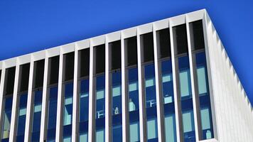 Modern office building in the city with windows and steel and aluminum panels wall. Contemporary commercial architecture, vertical converging geometric lines. photo