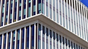 Modern office building in the city with windows and steel and aluminum panels wall. Contemporary commercial architecture, vertical converging geometric lines. photo