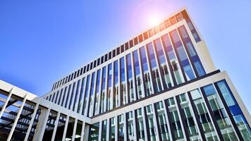 Modern office building in the city with windows and steel and aluminum panels wall. Contemporary commercial architecture, vertical converging geometric lines. photo