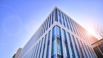 Modern office building in the city with windows and steel and aluminum panels wall. Contemporary commercial architecture, vertical converging geometric lines. photo