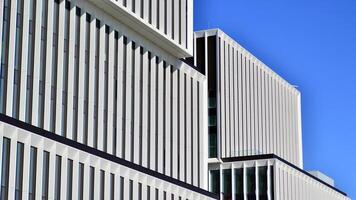 Modern office building in the city with windows and steel and aluminum panels wall. Contemporary commercial architecture, vertical converging geometric lines. photo