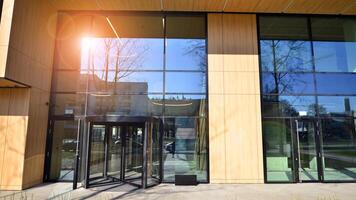 Entrance of the modern business city office building. Modern urban architecture. The front door of a office block, reflecting buildings in the glass. photo