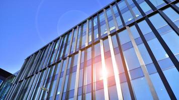 Modern office building with glass facade. Transparent glass wall of office building. Reflection of the blue sky on the facade of the building. photo