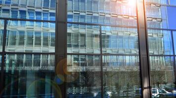 Modern office building with glass facade. Transparent glass wall of office building. Reflection of the blue sky on the facade of the building. photo