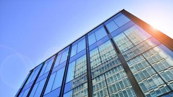 moderno oficina edificio con vaso fachada. transparente vaso pared de oficina edificio. reflexión de el azul cielo en el fachada de el edificio. foto