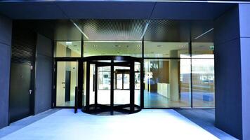 Entrance of the modern business city office building. Modern urban architecture. The front door of a office block, reflecting buildings in the glass. photo