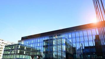 Modern office building with glass facade. Transparent glass wall of office building. Reflection of the blue sky on the facade of the building. photo