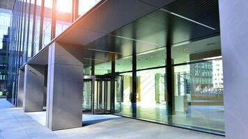 Entrance of the modern business city office building. Modern urban architecture. The front door of a office block, reflecting buildings in the glass. photo