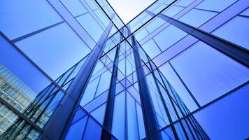 Modern office building with glass facade. Transparent glass wall of office building. Reflection of the blue sky on the facade of the building. photo